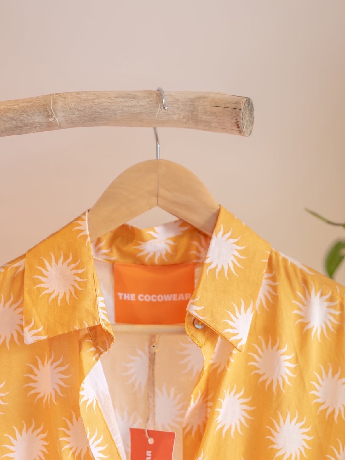 A yellow sun-print Cocowear shirt on a hanger