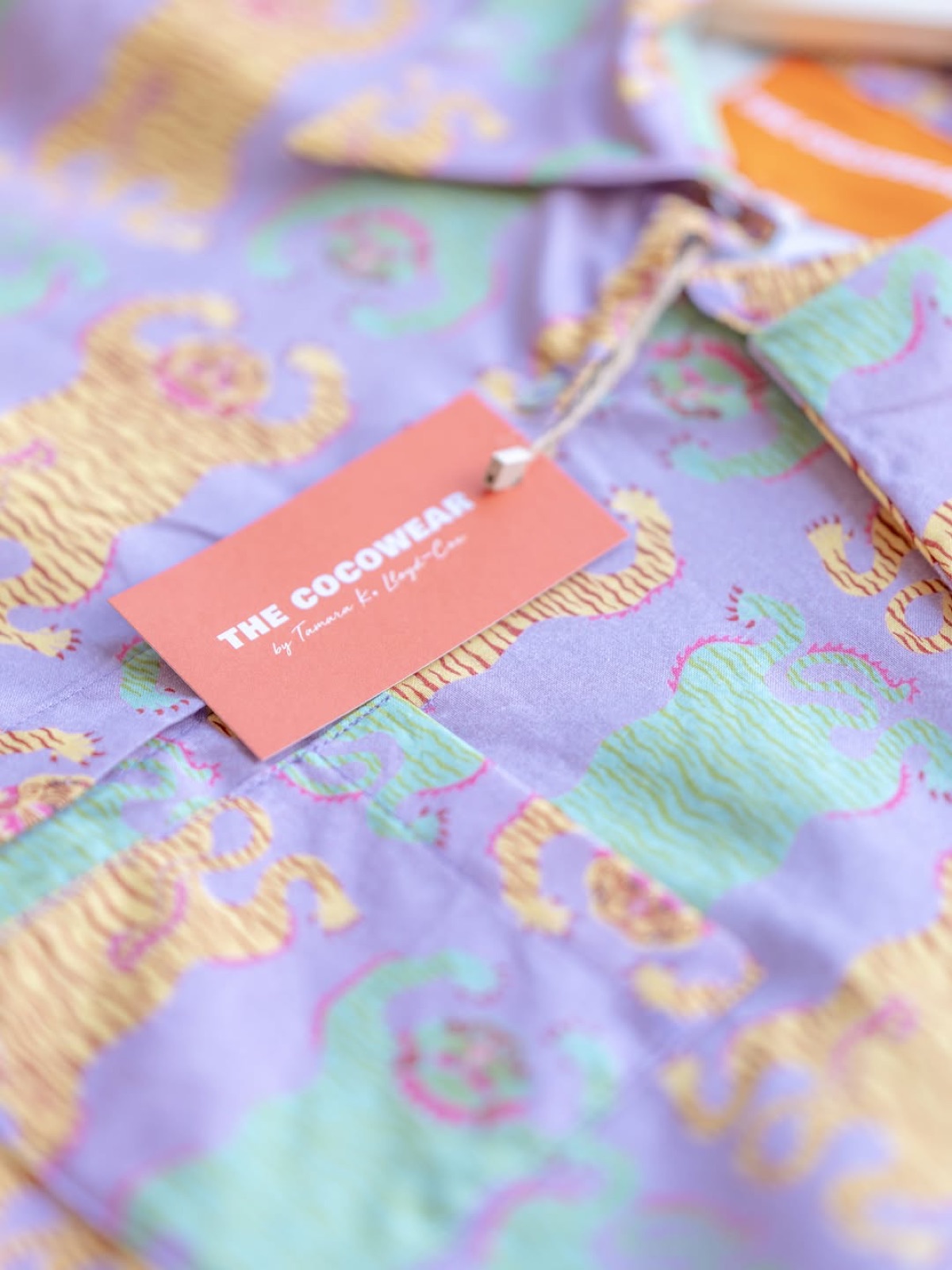 A purple and green patterned Cocowear garment, detail