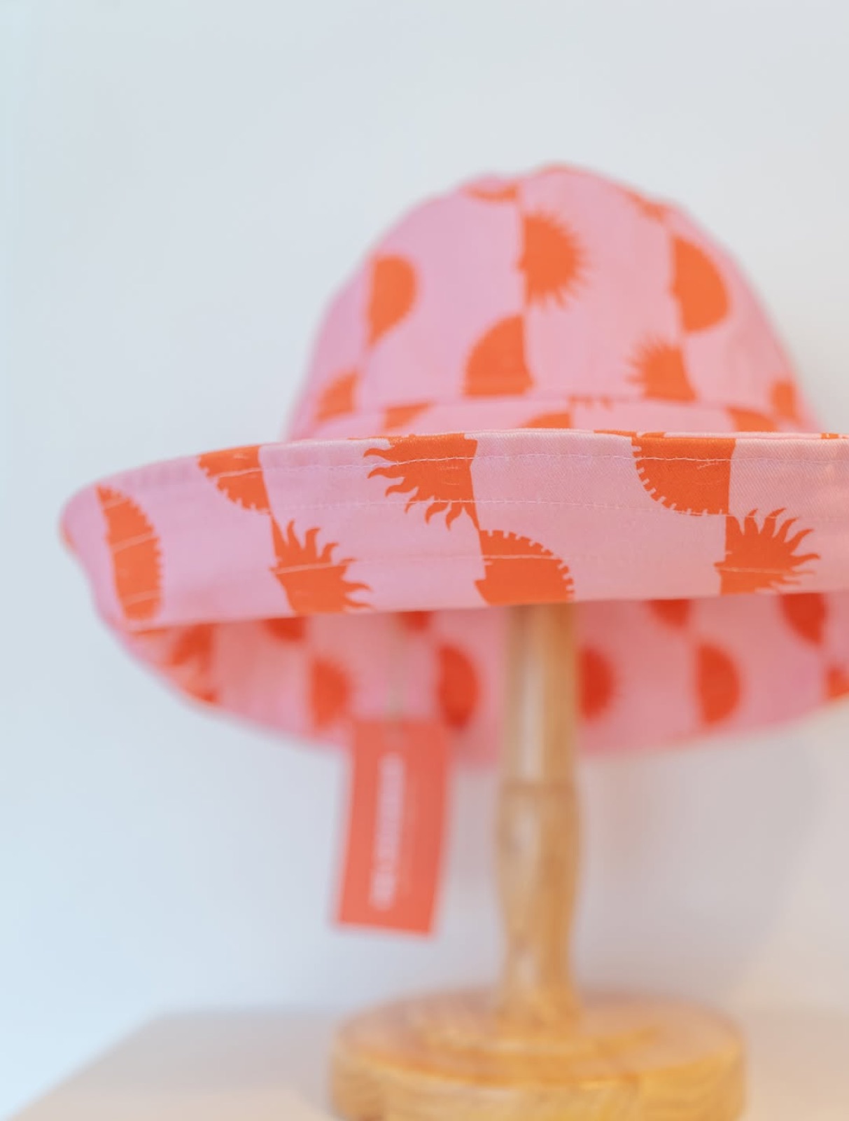 A pink and orange patterned Cocowear sun hat
